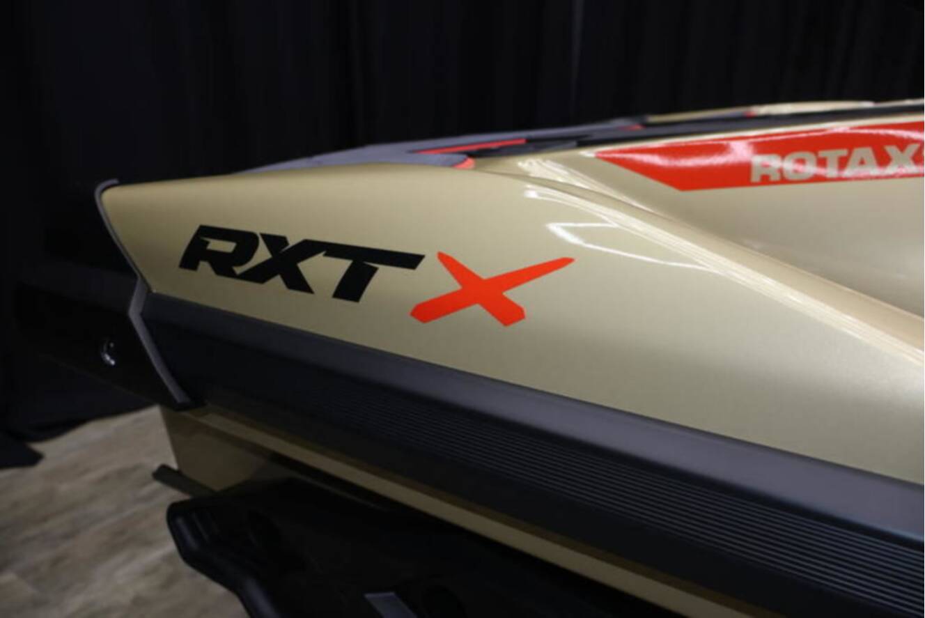 A photo of this 2025 Sea-Doo RXP-X 325 iBR Metallic Tan / Lava Red Premium