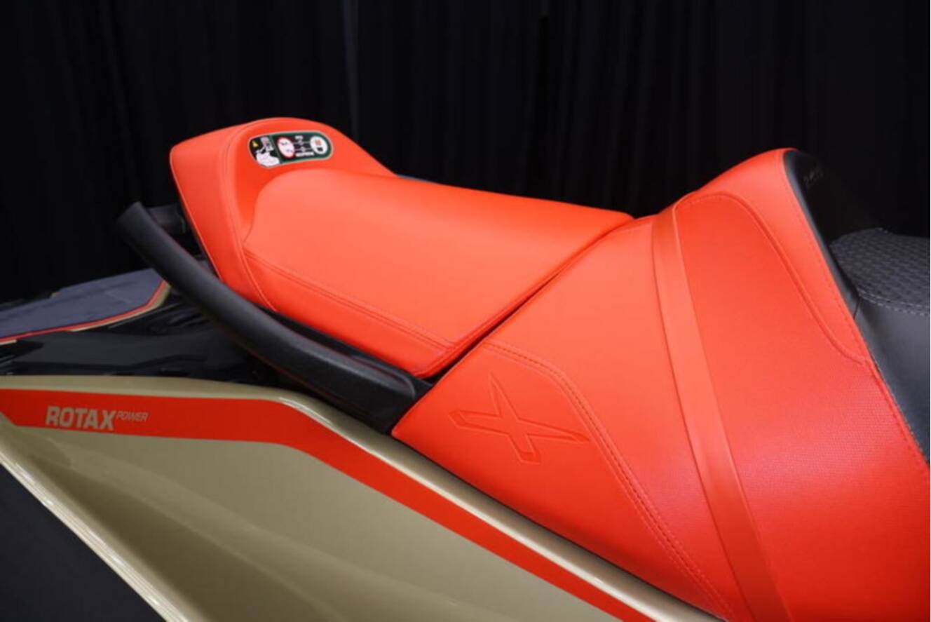 A photo of this 2025 Sea-Doo RXP-X 325 iBR Metallic Tan / Lava Red Premium